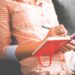 Collectable Quotes from Proverbs 29; A woman in a orange dress sits in a chair with a diary and a pen in her hand.
